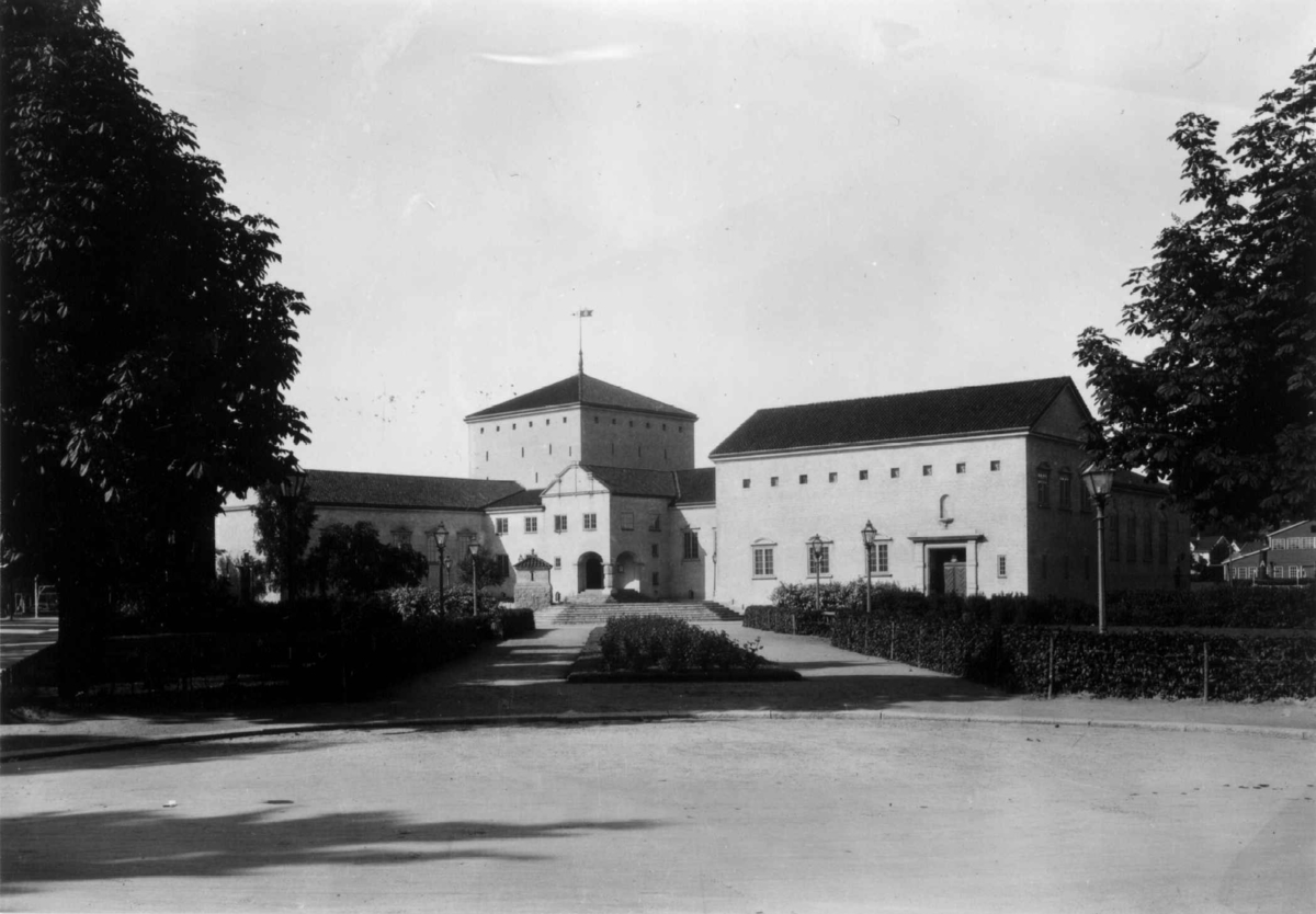Hermann Christian Neupert, Biblioteket i Fredrikstad i Østfold fotografert i 1930. Stor murbygning omgitt av parkanlegg med trær, busker, gangveier og lykter.