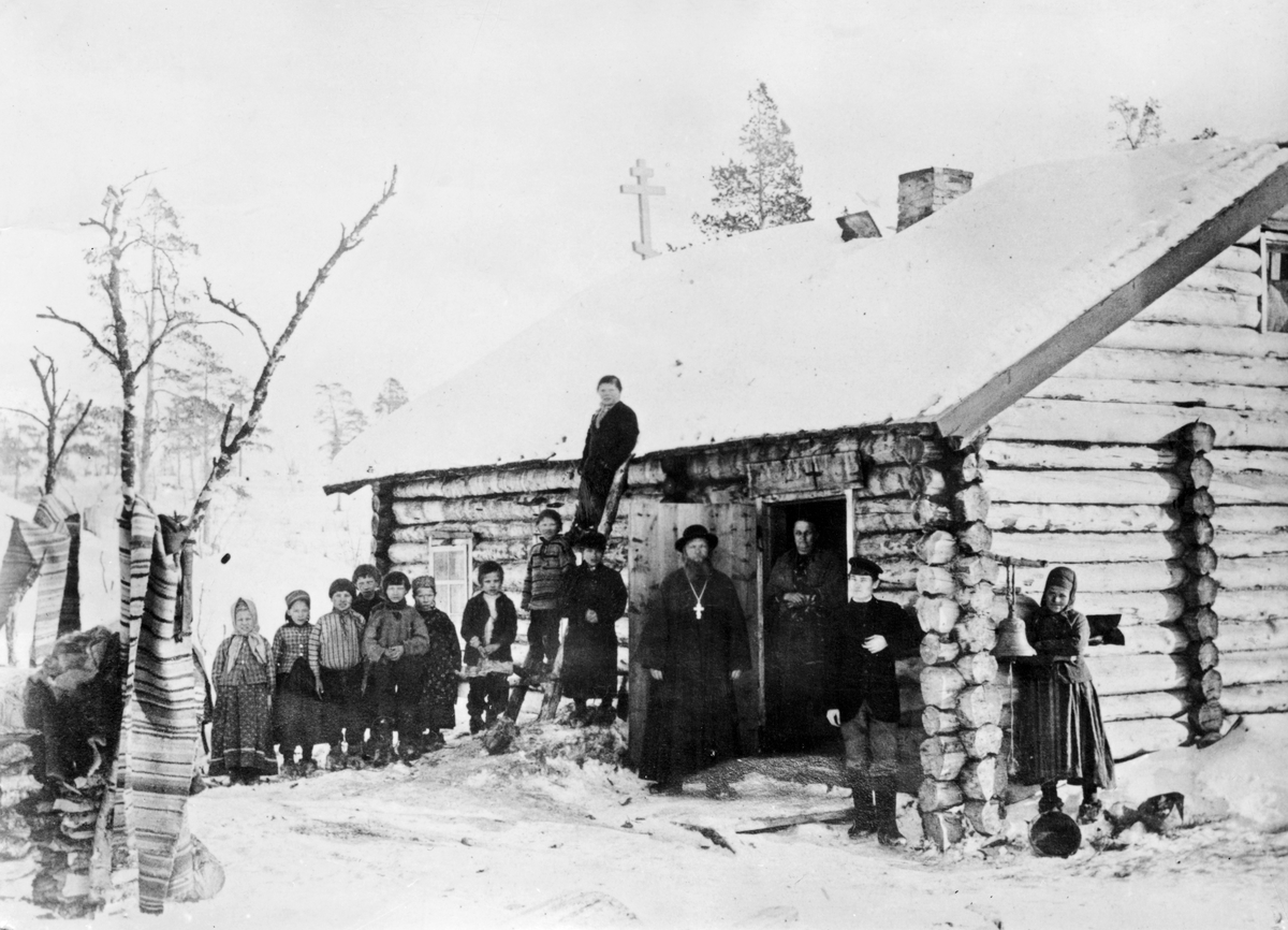 Ellisif Rannveig Wessel, Prosten med kone, klokkeren og skoltesamiske skolebarn ved russisk skole og kapell, Pasvik, Sør-Varanger, Finnmark, ca. 1898.