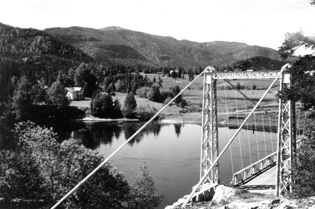 Hermann Christian Neupert, Gulsvik, Flå. 1932. Oversiktsbilde. Landskap med gårder. Skog og fjell. Elv og bro i forgrunnen.