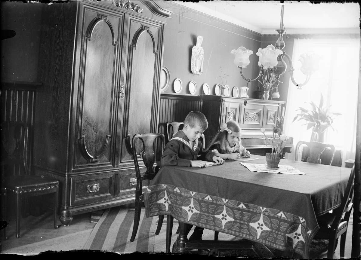 Skötsner-Edhlund, Children sitting at a table and reading and writing, Östhammar, Uppland