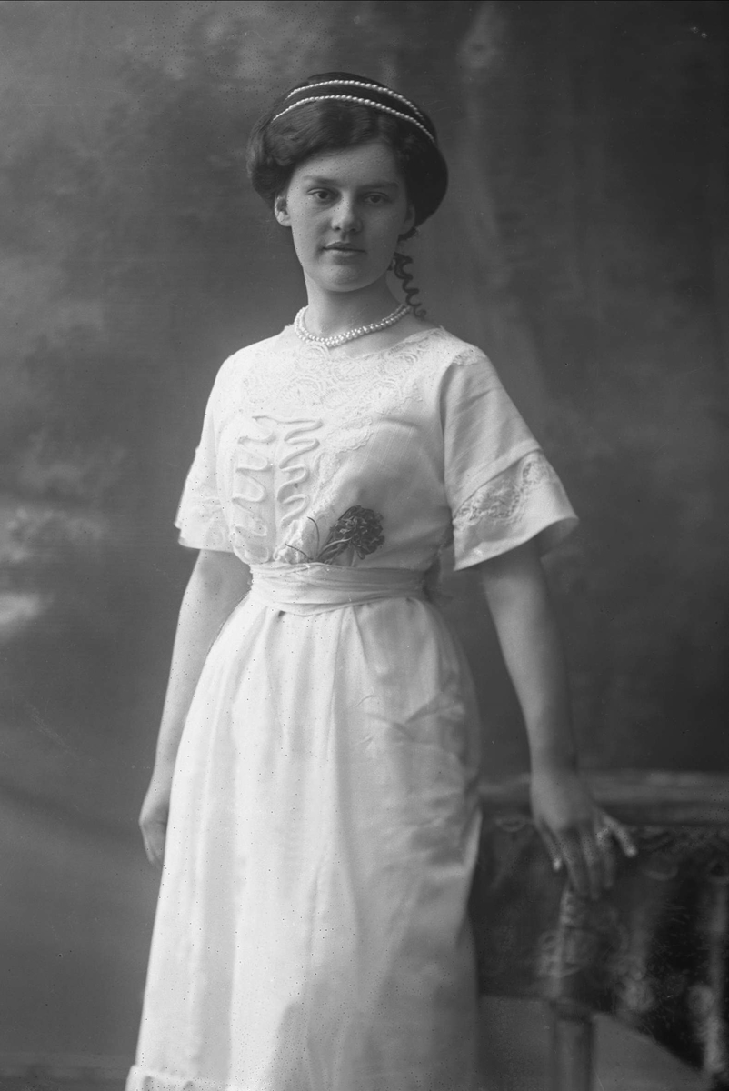 Gustav Borgen, Portrett, kvinne med lys kjole og perlebånd i håret og om halsen. Frøken Constance Johansen.