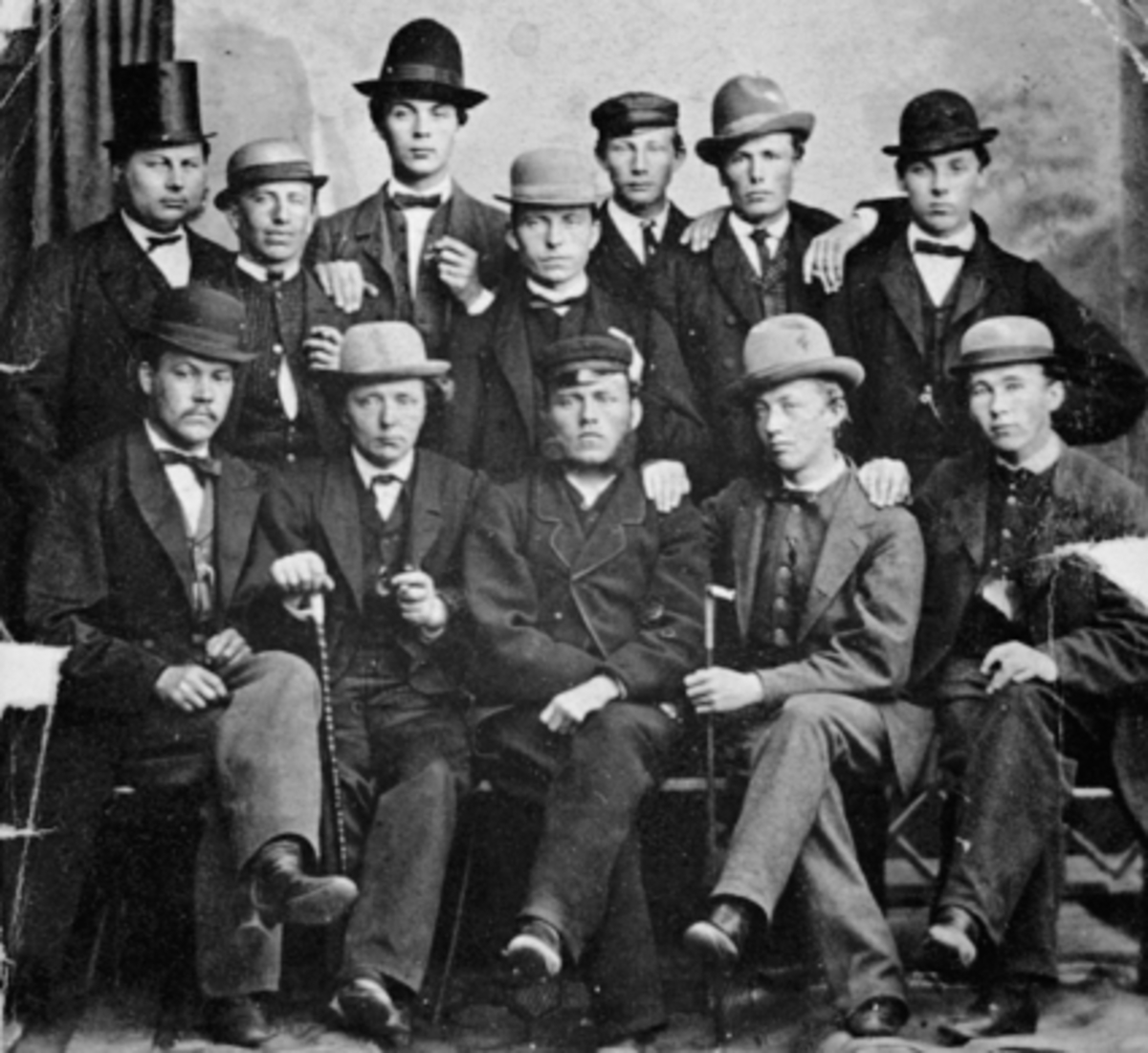 Anno Domkirkeodden, Gruppe, 12 Menn, studio, forskj. hatter, Hamars yngre handelsstand. Første rekke fv: Ole Bredstue, Bernt Øvergård, Oskar Svendsen, Gudbrand Øvergård og Martinus Remmen. Andre rekke fv: J. Windhoel og A. Jølstad. Bakerste rekke fv: J. T. Hansen, Erik Eriksen, Johs. Paulsberg, Bernt Berg og Ole Eriks…