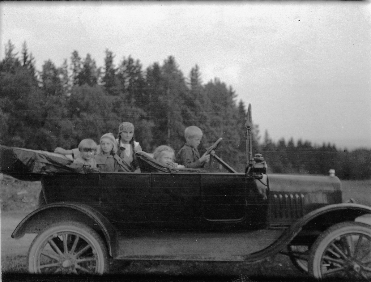 Ragnvald Andersen, Mange barn sitter i en bil. Ford?