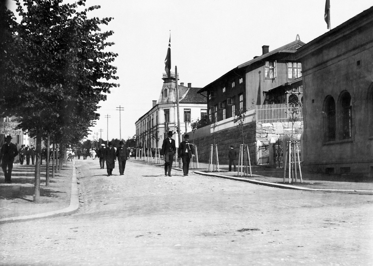 Anno Domkirkeodden, Oversikt fra krysset Parkgata, Grønnegate mot Parken i Hamar, folk i finpussen kommer nedover. Folkeavstemmingsdagen, folkeavstemning om kongedømme eller republikk i Norge. Huset bakerst ble bygd av Hamar Håndverkerforening og ble innviet 16. februar, 1890. De leide ut rom her til blant annet Hamar…