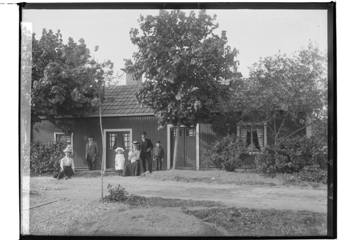 Samuel Lindskog, Envånings dubbelhus, 7 personer framför byggnaden. Karl Thorén