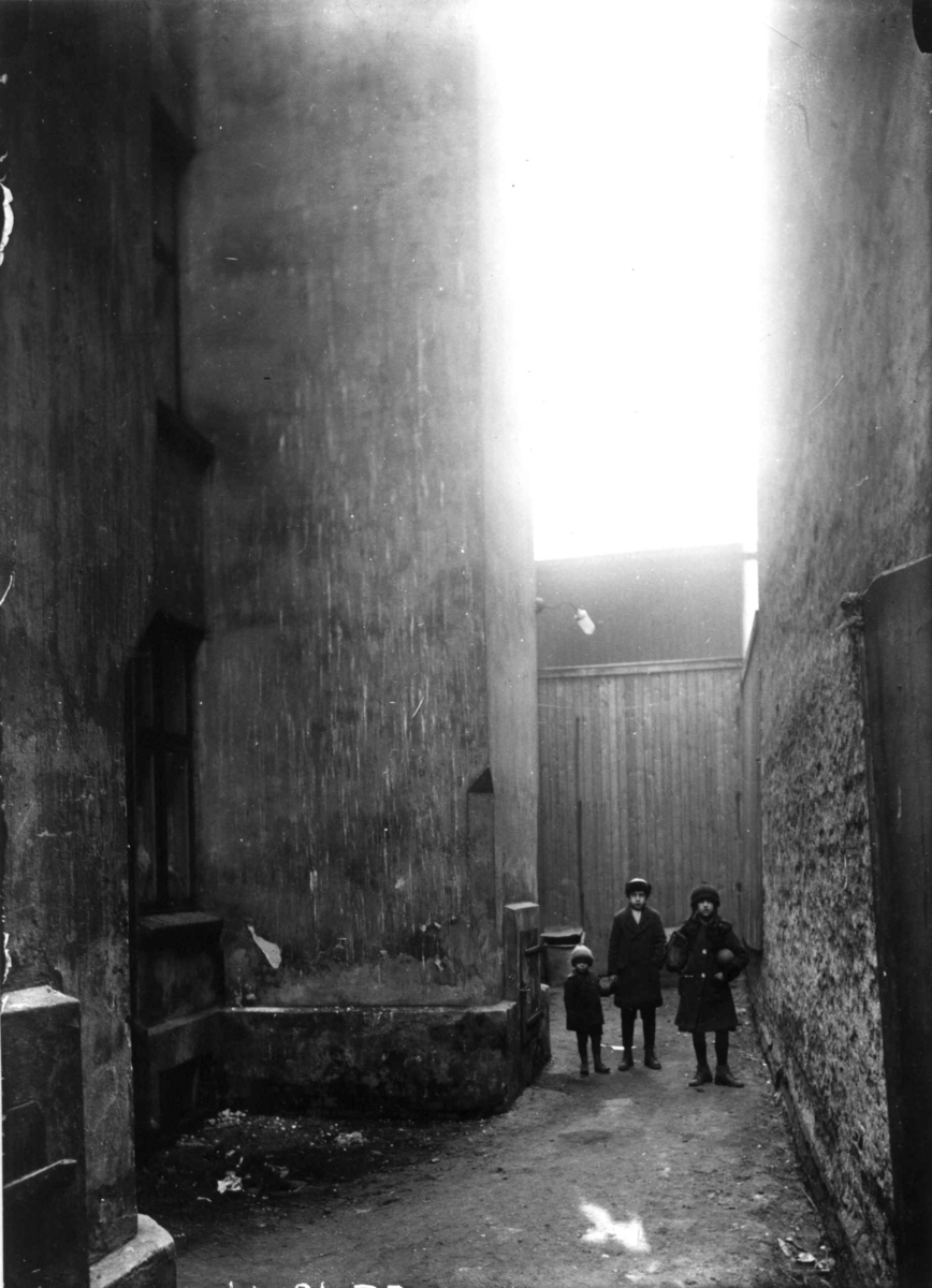 Nanna Broch, Fra gårdsrom, bygårder, Oslo. Barn poserer. Muligens Gråbeingårdene, Tøyen. Fra boliginspektør Nanna Brochs boligundersøkelser i Oslo 1920-årene.