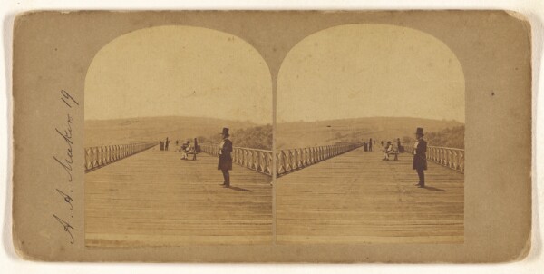 Unknown, [Man with top hat standing on long wooden bridge]