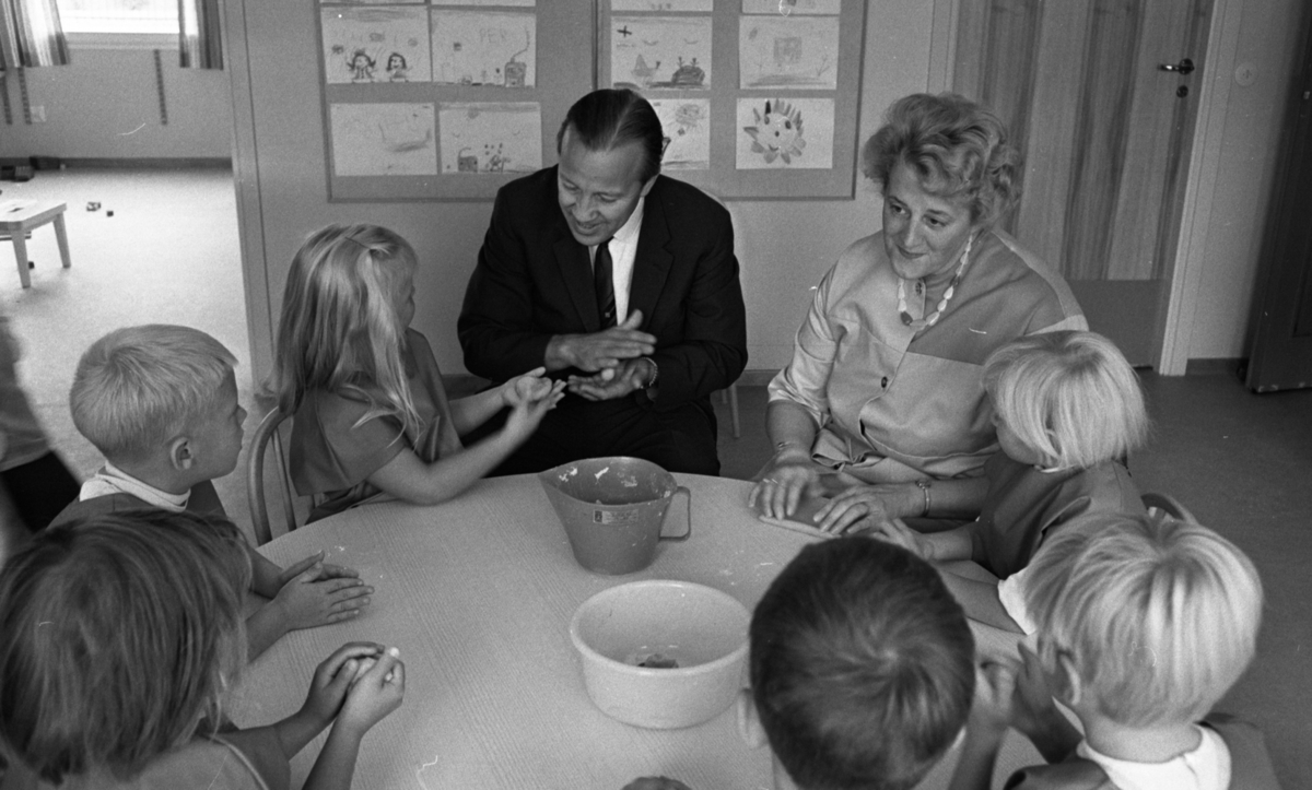 Örebro Kuriren, Children’s Day Care 9 September 1966 At a table sits a preschool teacher and a man in a black suit with the children and plays with a spell. Behind them you see drawings on the wall.