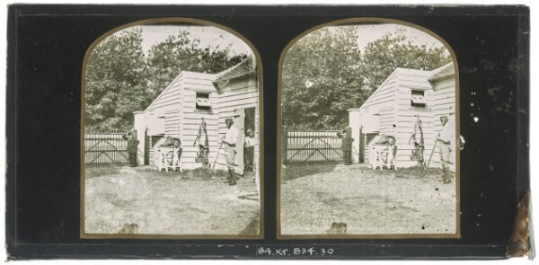 Unknown, [Three unidentified British men standing in front of a stable]