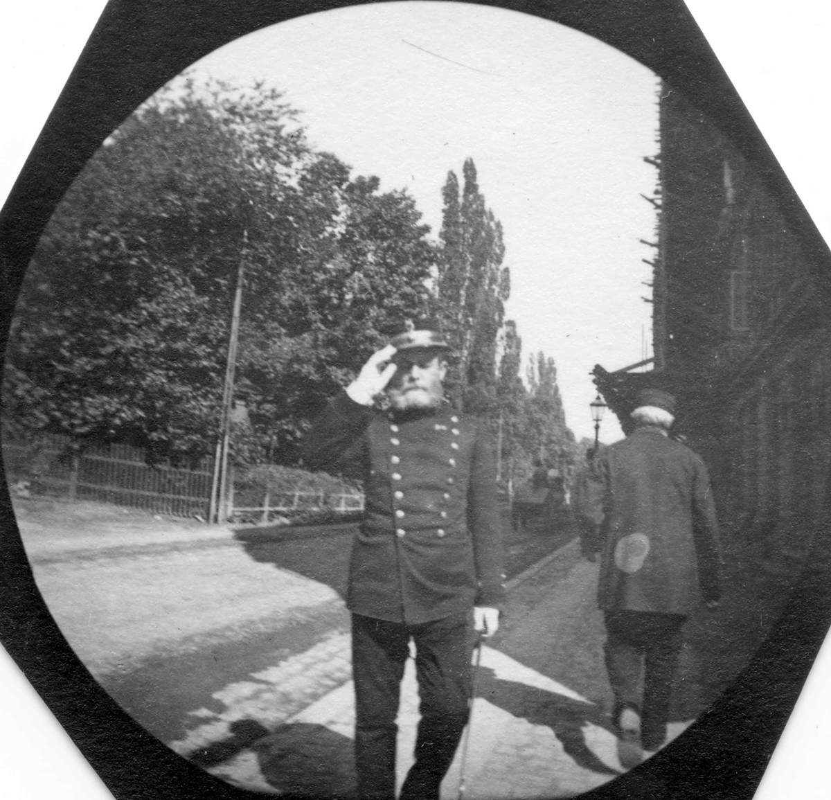 Fredrik Carl Mülertz Størmer, General P. Nissen gjør honnør i bygate. Bygårder på den ene siden av gata, park på den andre.
