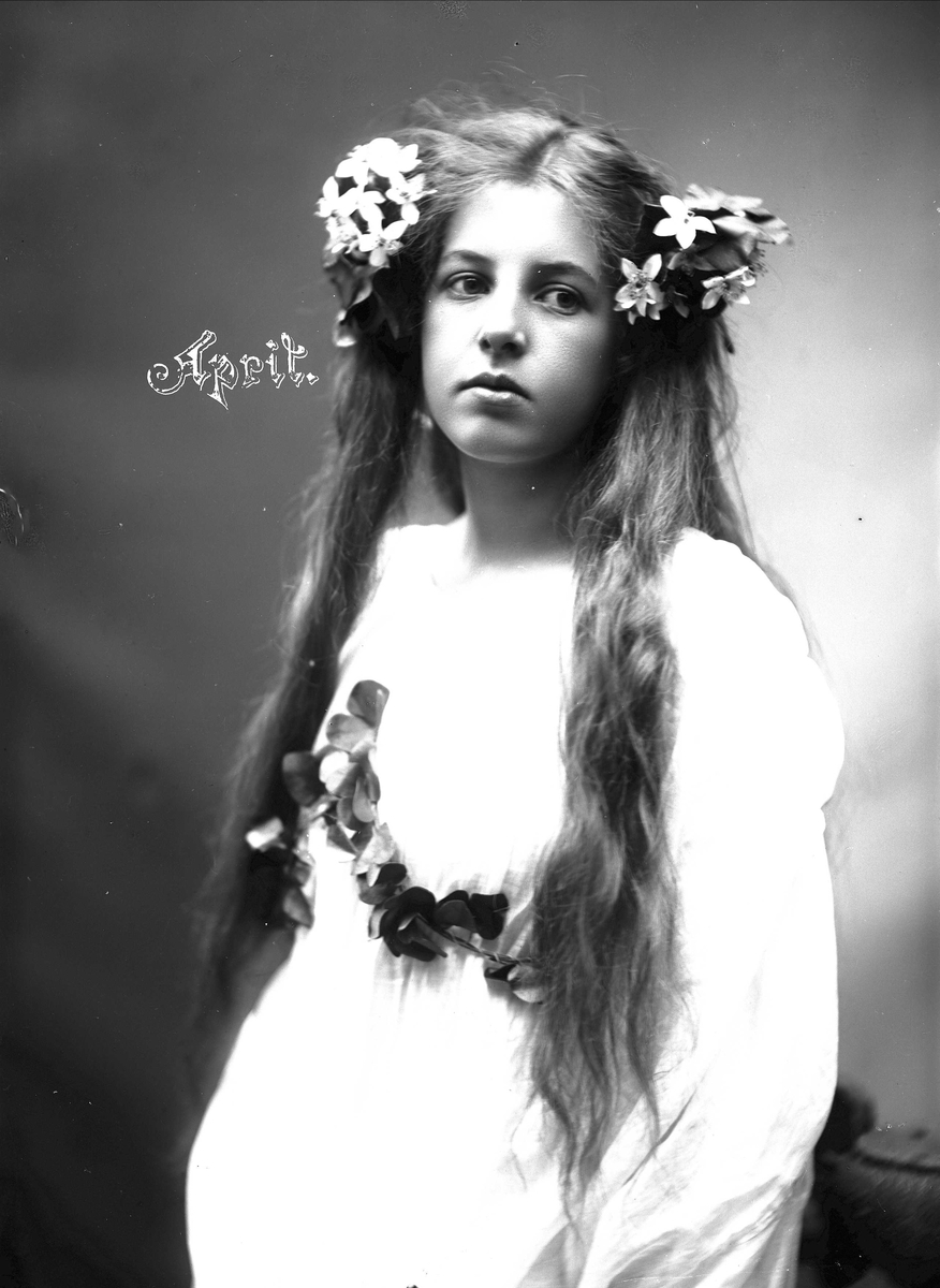Solveig Lund, Studioportrett av kvinne i drakt med blomster i håret.
