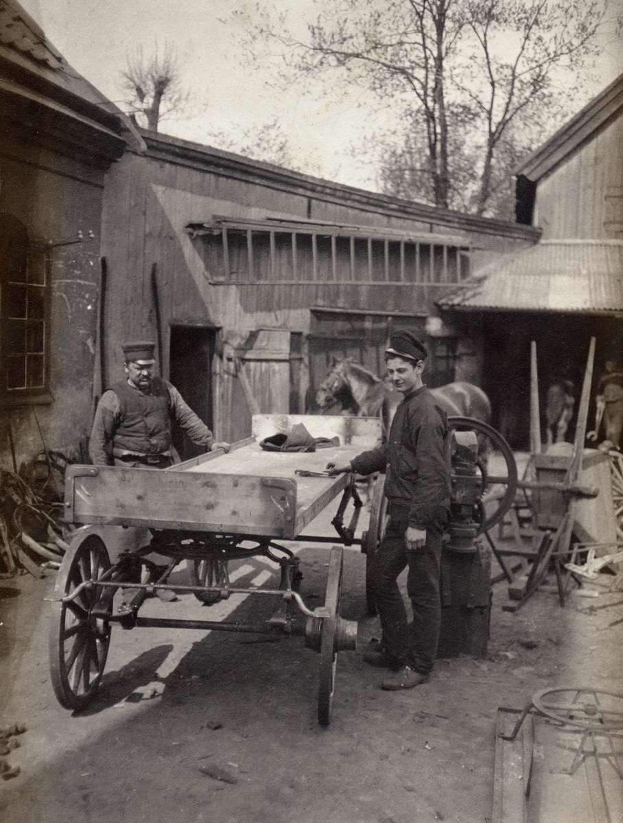 Okänd,, Arbetare vid vagn utanför kvarnsmedjan, Akademikvarnen, kvarteret Holmen, Uppsala juni 1909