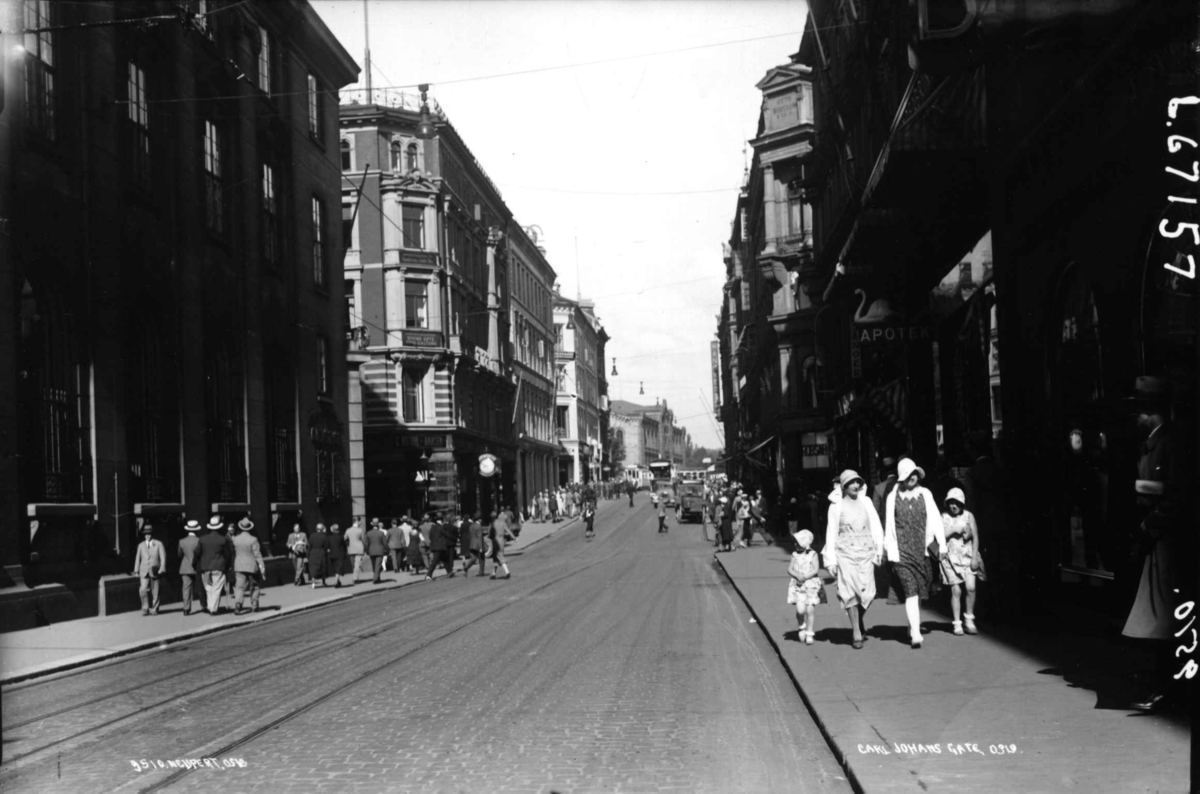 Hermann Christian Neupert, Karl Johans gate, Oslo. Gatebilde med mennesker, biler og trikker.