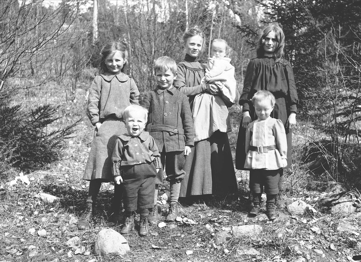 Axel Quinsgaard Wiborg, Familiegruppe, Margrethe Q. Wiborg, fotografens kone, med barn/stebarn utendørs, Digerud, Frogn, Akershus, 1906. Fra venstre: Gudrun (Dudo), Thor, Axel, Margrethe med minste sønn, Simon på armen, Karen Mathilde (Lillemor) og Halvor Nicolay.