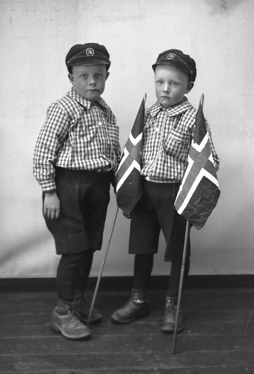 Per K. Lien, Tvillinger i kortbukser og ullstrømper, med flagg.
