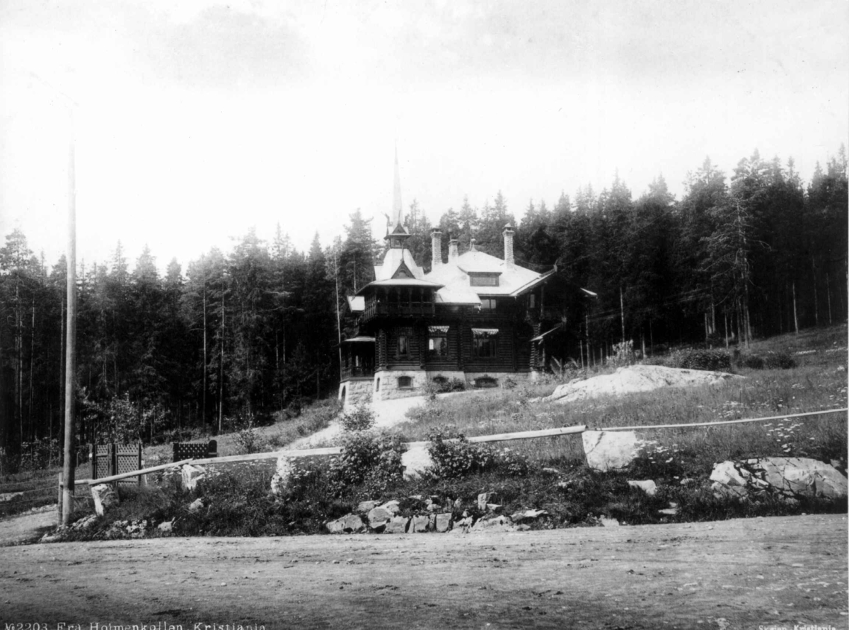 Marthinius Skøien, Fra Holmenkollen, Oslo. Tømmerhus med tårn. Sett fra veien nedenfor.