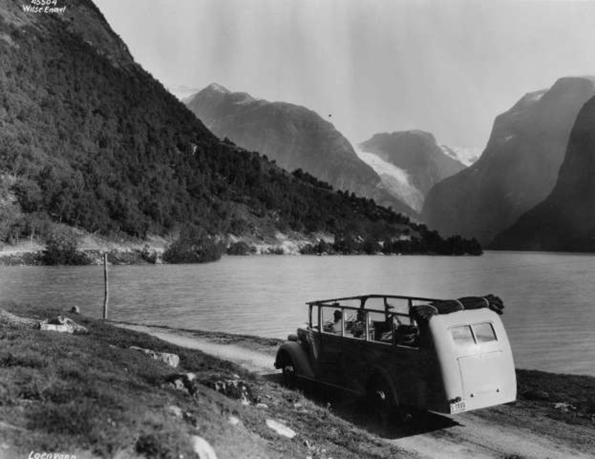 Anders Beer Wilse, Åpen minibuss på veien ved Lovatnet i Stryn. Fjord og fjell