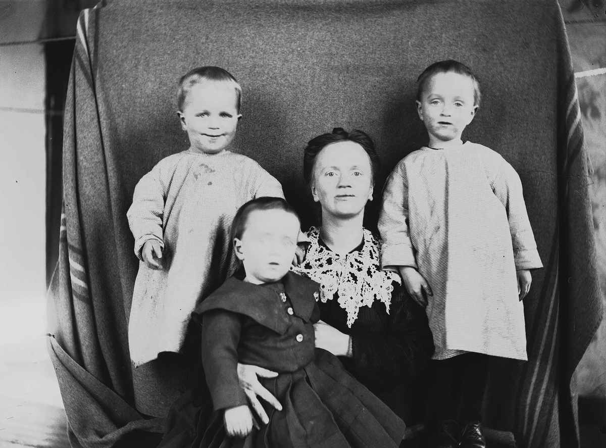 Axel Quinsgaard Wiborg, Portrett av Thor, Halvor Nicolai (ant. foran), mor Margrethe og Simon Q. Wiborg, Digerud, Frogn, Akershus, mars 1907. Fotografert mot opphengt bakteppe.