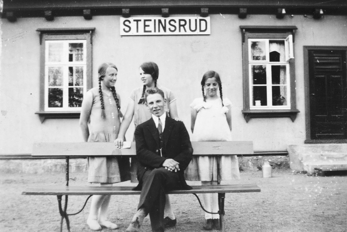 Ukjent, Steinsrud jernbanestasjon i Stange. "Boligen" i 1930. Martin Korslund sitter på benken. Bak f. v. Ester Korslund, Borghild Korslund og Edel Korslund. Flere opplysninger se boka "Handelsteder i Stange" skrevet av Jan Arne Berg, utgitt av Stange Historielag 2012