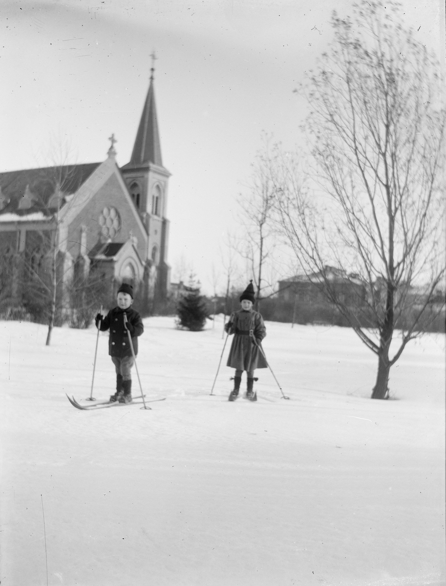 Carl Liljefors, Olle och Carin Liljefors på skidor framför Mikaelskyrkan, Uppsala 1900 - 1901