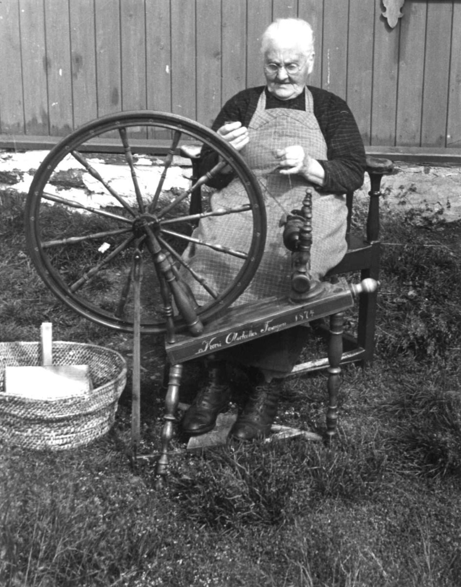 Anna Grostøl, En kvinne sittter ved rokken og spinner. Brekken, Røros, Sør-Trøndelag 1938.