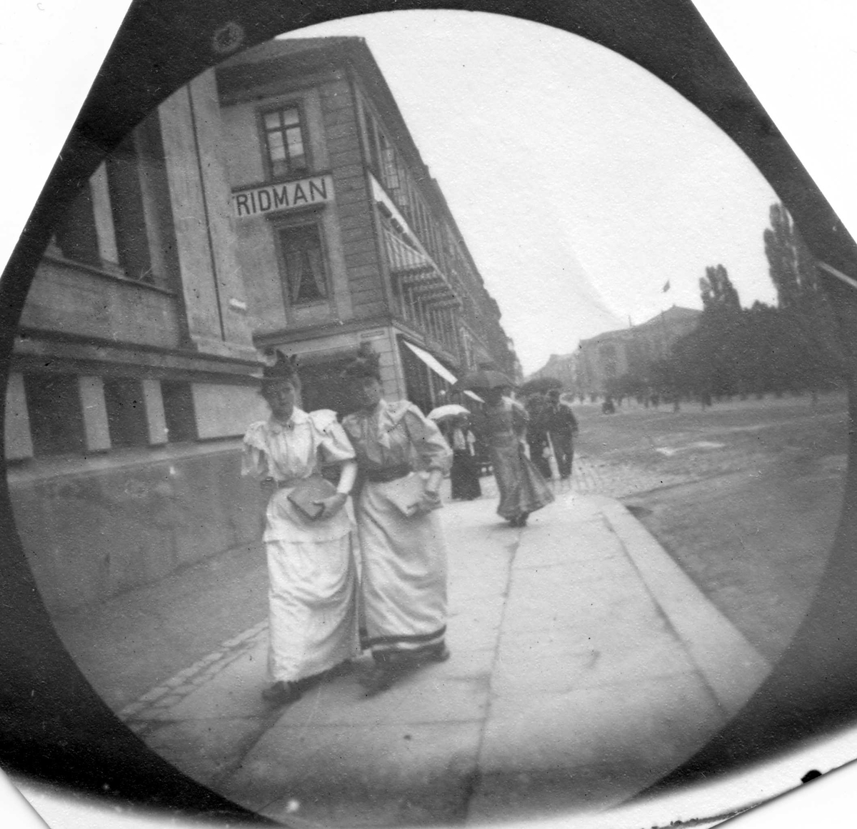 Fredrik Carl Mülertz Størmer, Frk. Bonnevie og frk. Løvenskiold spaserer langs Karl Johans gate, Oslo, ved Universitetet.