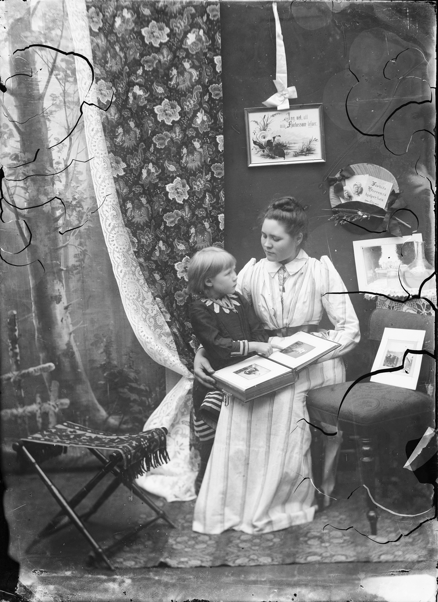Skötsner-Edhlund, Ruth Skötsner och Brita Edhlund tittar i fotoalbumet, på far och maken, Anders Skötsner, Östhammar, Uppland