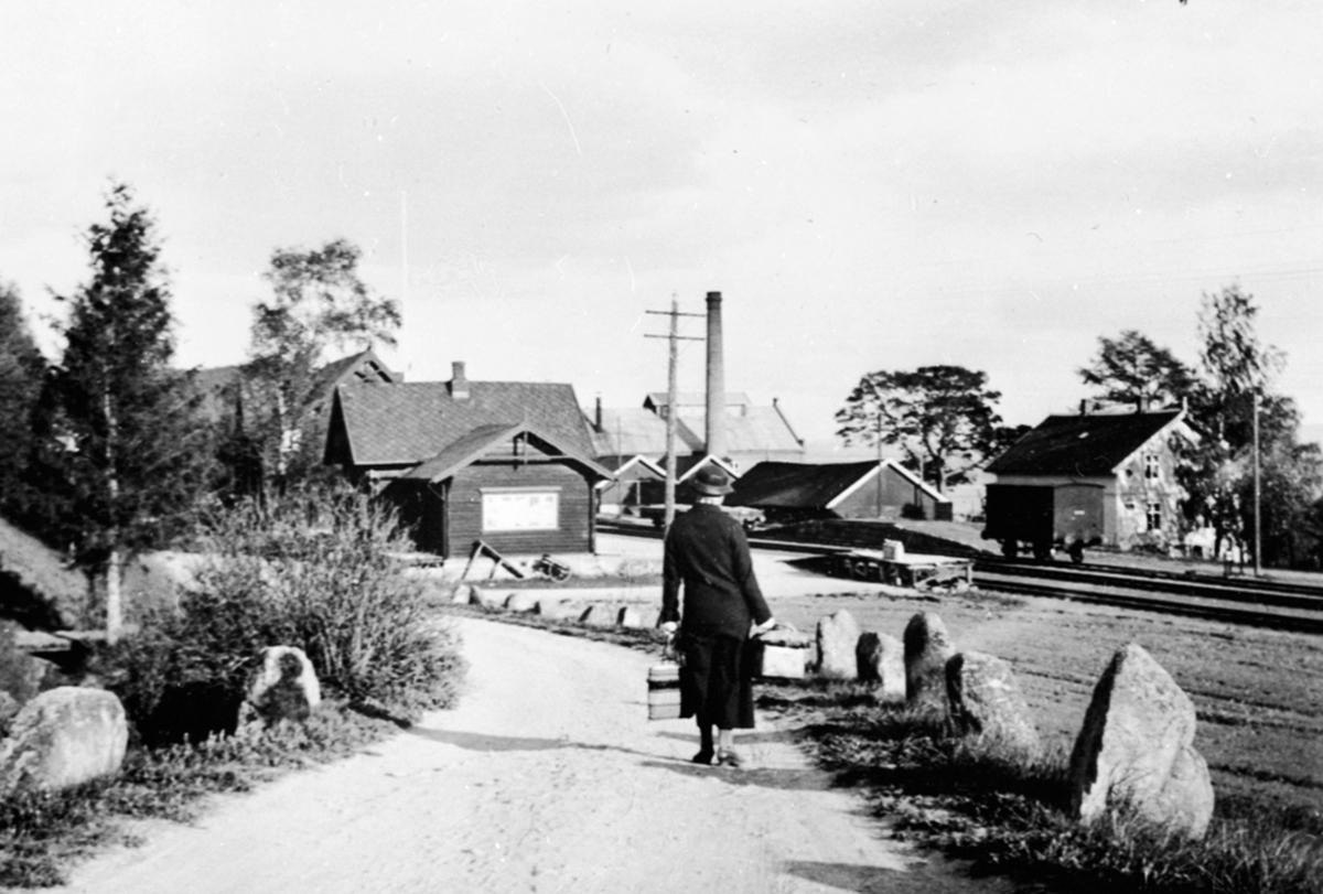 Anno Domkirkeodden, Dame på veg ned til Jesnes stasjon, Arnkvern Møllesteinsfabrikk i bakgrunnen.