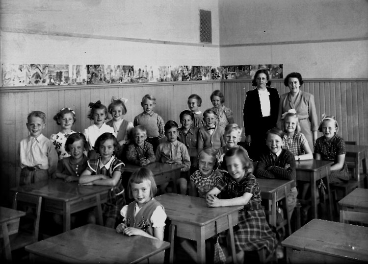 Sven Lindskog, Almby Norra skola, klassrumsinteriör, 20 skolbarn med lärarinna fröken Märta Larsson och vikarie fröken Hedlund. Klass 2aj, sal 3.