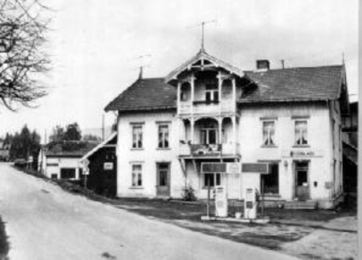 Anno Domkirkeodden, Eksteriør. Forretning. Elektor Auto. Bensinstasjon. Revet i 1979. Til høyre kan man skimte jernbanebrua over Moelva. Idag er det kun en grønn plen på dette stedet. Bygget av Sundgård i Nedre Brovold på tomt fraskilt Mo. Navnet på eiendommen var Linrud