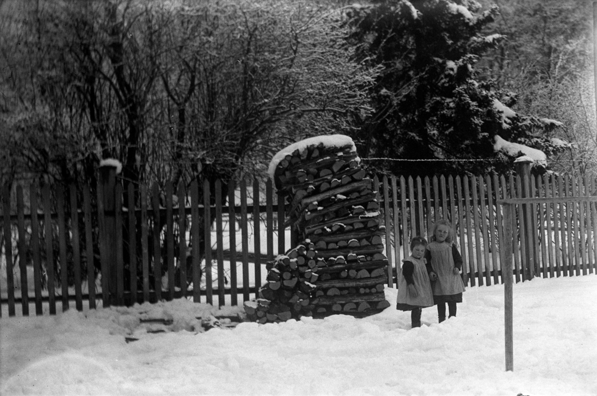 Johannes Larsen Alhaug, Karen og Margit Alhaug ved en vedstabel. Holmsgården, St. Olavsgate 66, Hamar.