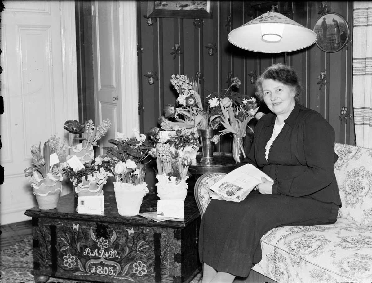 Skötsner-Edhlund, Woman in a Home Environment surrounded by flowers, Östhammar, Uppland