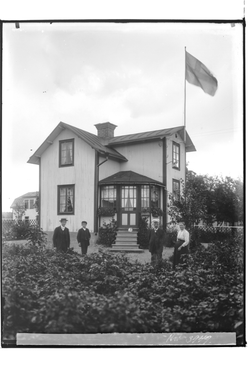 Samuel Lindskog, En och en halvplans bostadshus med glasad veranda , 4 personer framför huset. Repslagare Karl Helander.