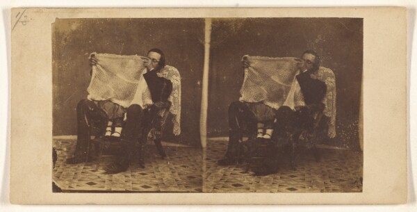 Unknown, [Man seated with a child on his lap, looking through gauze-like fabric]