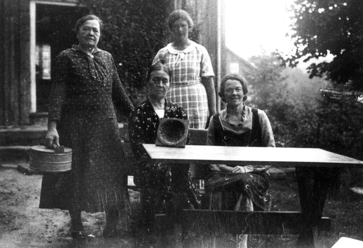 Anna Grostøl, Gjerstad, Aust-Agder 1936. De tre søstrene Ingebjørg, Torine og Anna Moe og Nina Nordbye med smørform og graut-bøtte ved et bord.