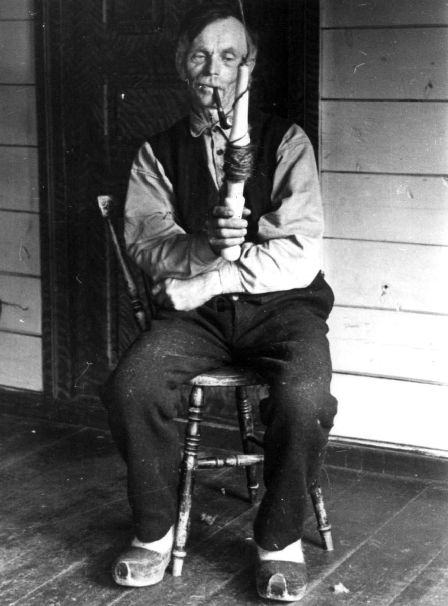 Anna Grostøl, Sigmund Rudlende på Rossevatn spinner på håndrokk. Eiken, Hægebostad, Vest-Agder 1941.