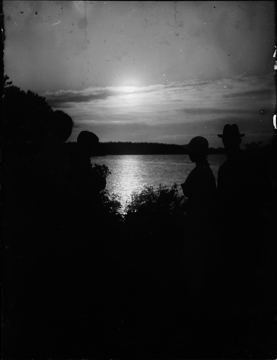 Skötsner-Edhlund, Siluett av kvinnor och män i motljus vid vattendrag, Östhammar, Uppland
