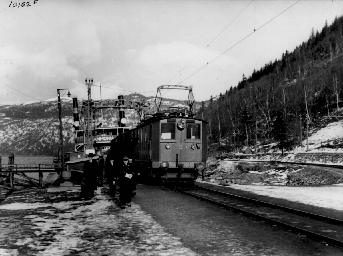 Anders Beer Wilse, Dampfergen Ammonia og et av Rjukanbanens elektriske lokomotiver fra 1911 på Mæl stasjon. Jernbanevognene ble fraktet med ferge på Tinnsjøen mellom Mæl og Tinnoset.