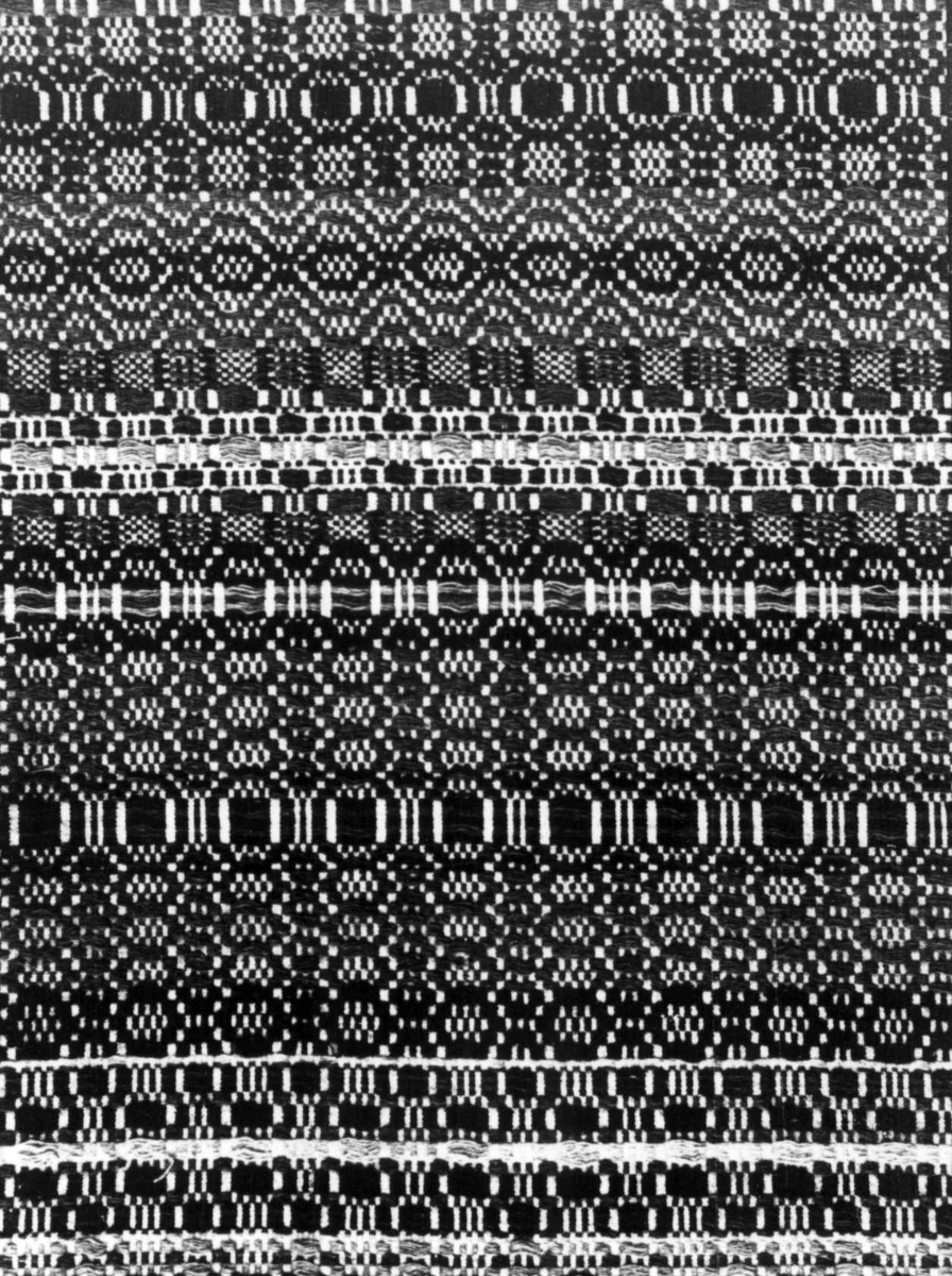 Anna Grostøl, Iveland, Vest-Agder 1941. Teppe, detalj av skillbragd vevd ca. 1860.