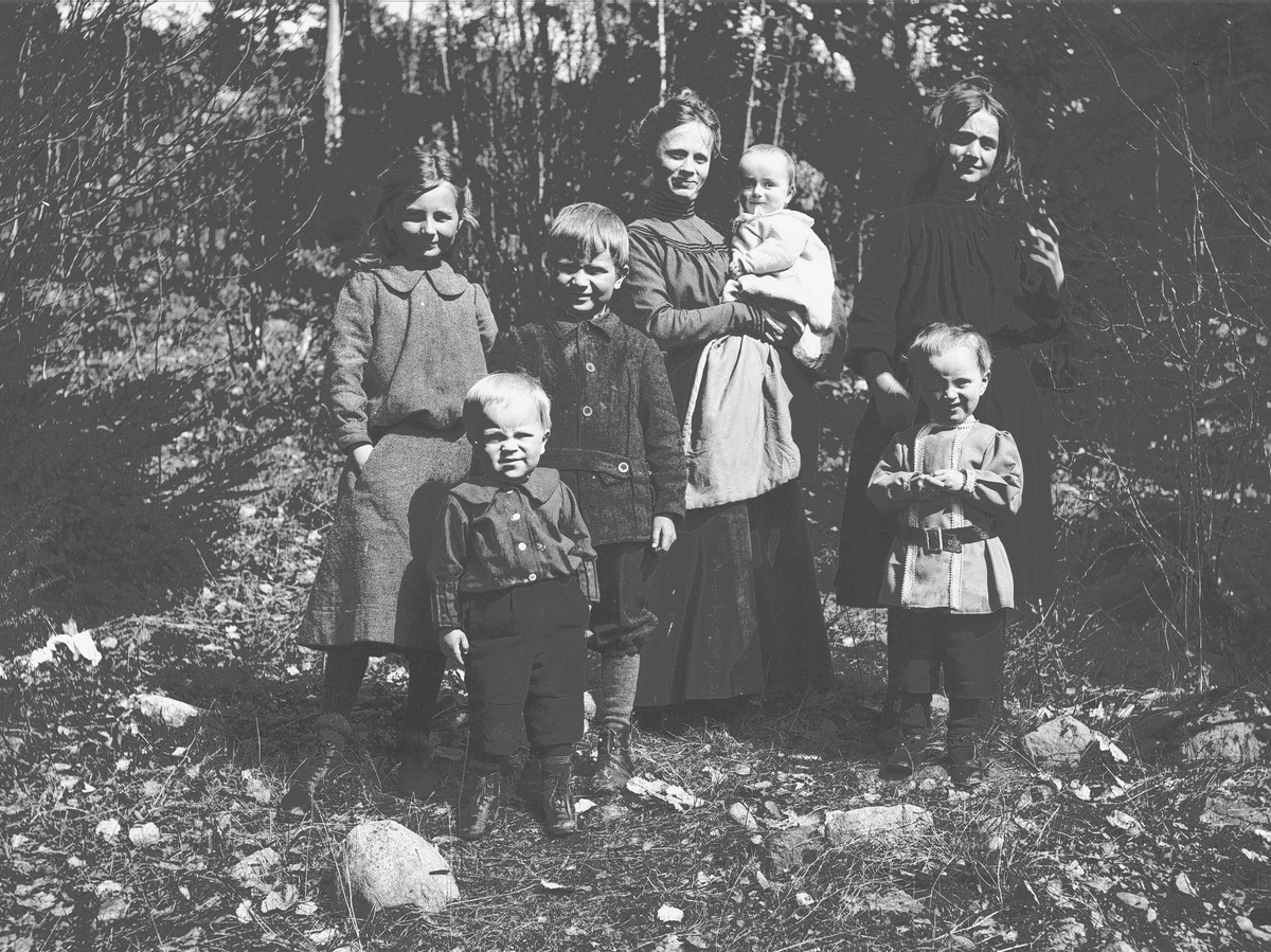 Axel Quinsgaard Wiborg, Familiegruppe, Margrethe Q. Wiborg, fotografens kone, med barn/stebarn utendørs, Digerud, Frogn 1906. Fra venstre: Gudrun (Dudo), Thor, Axel, Margrethe med minste sønn, Simon på armen, Karen Mathilde (Lillemor) og Halvor Nicolay.