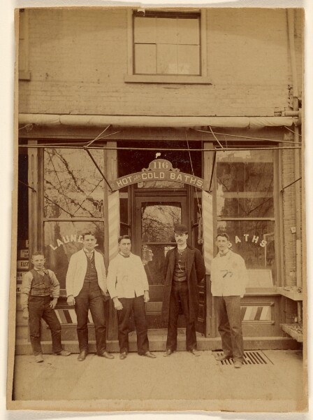Unknown, [Four men and a boy standing in front of a public bath house]