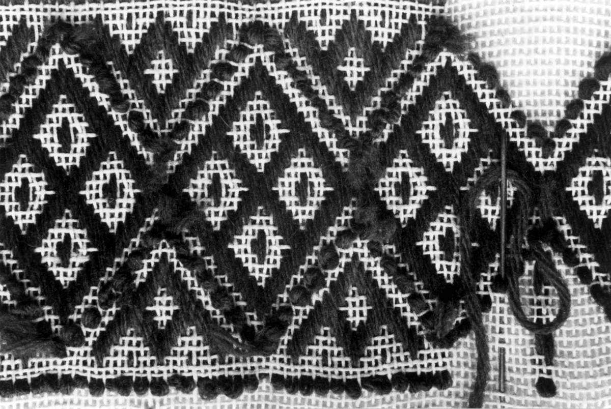 Anna Grostøl, Valle, Aust-Agder 1938. Detalj av brodert brettholder i gåsøymønster.