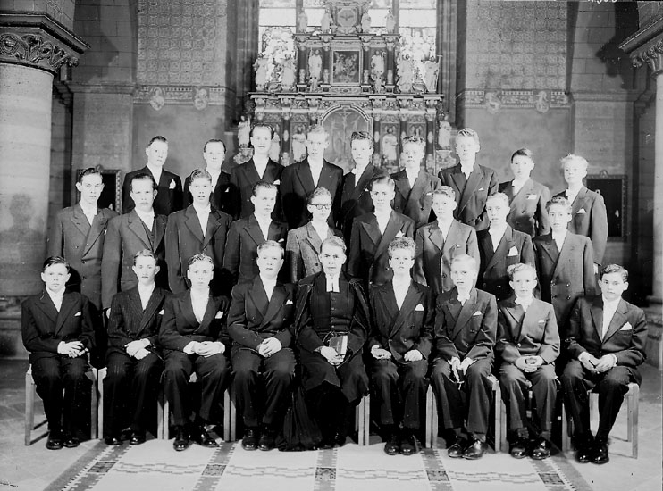 Samuel Lindskog, 26 konfirmander, 26 pojkar och pastor Ragnar Ekström. Interiör av Nikolaikyrkan.