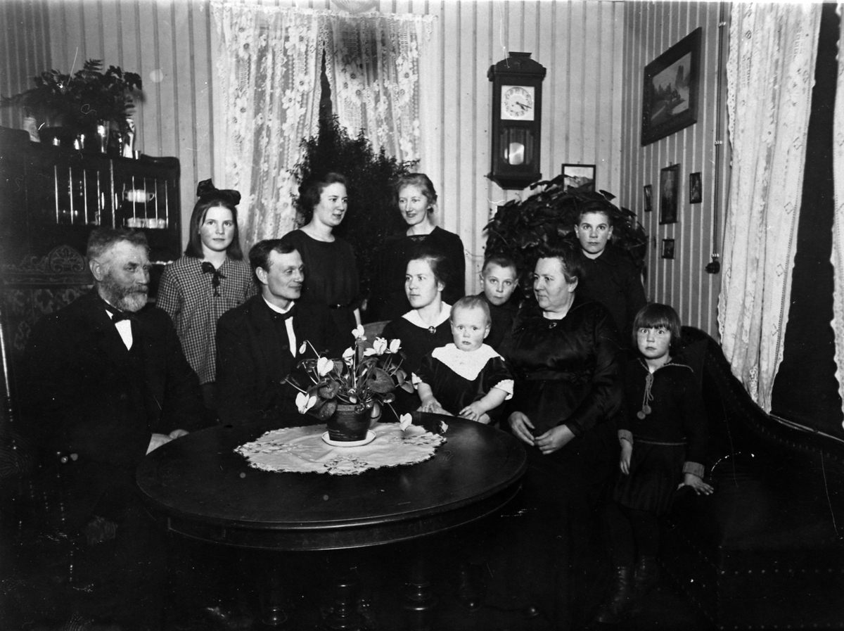 Anno Domkirkeodden, Gruppe barn og voksne i stue. Foran fra venstre er Anders Randgaard, Johannes O. Syljuberget, Lene Randgård, Edle Syljuberget, Ivar Randgård, Jørgine Freng, Gerd Randgård. Bak fra venstre er Astrid Randgård, Kristine (Kett) Randgård, Karen Bjørli, Ole Randgård, ca. 1922.