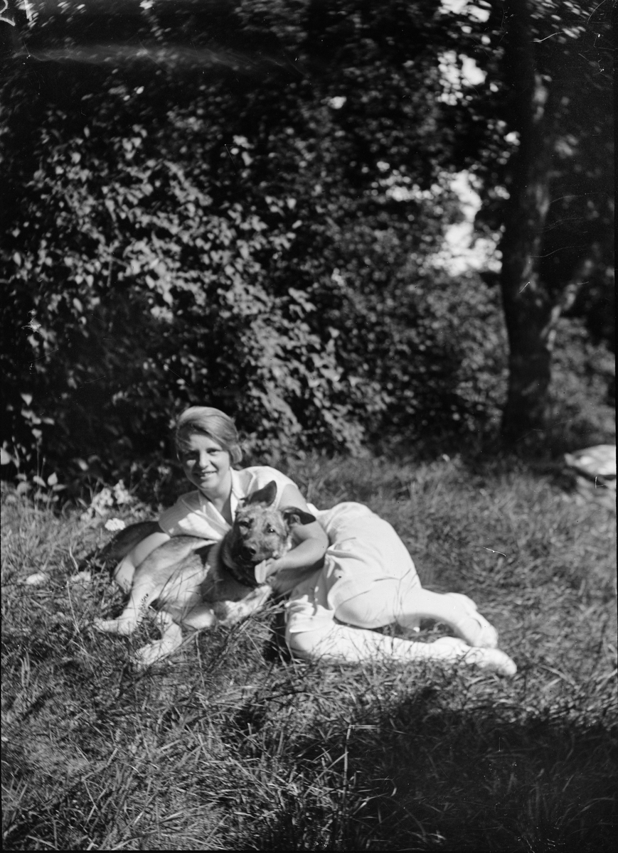 Okänd,, Christiane och Ruben Liljefors dotter Marit med hund i trädgården, sannolikt i Gävle