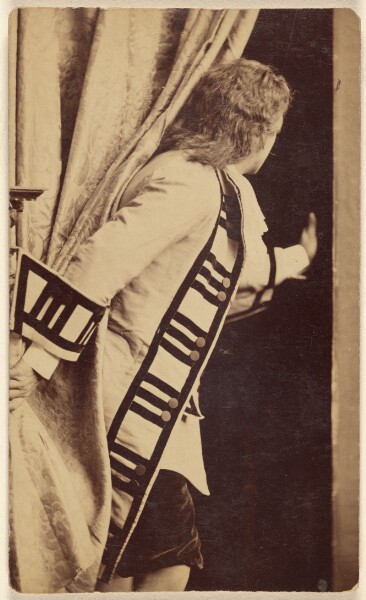 Unknown, [Unidentified man in costume with back to camera, going through side of a curtain]