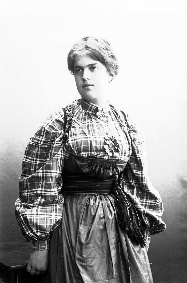 Solveig Lund, Studioportrett av kvinne i drakt med oppsatt hår.