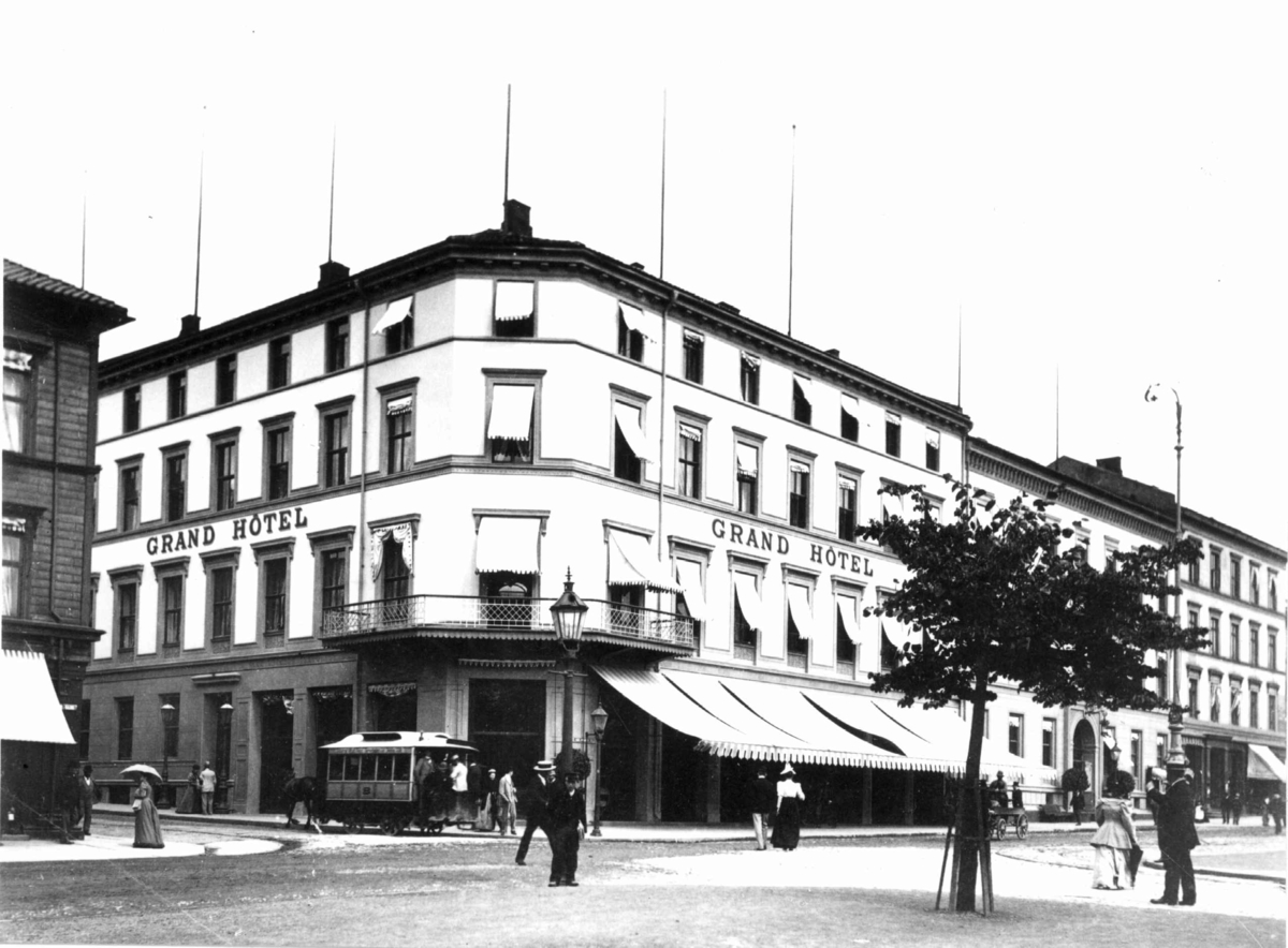 Axel Lindahl, Grand Hotel, Karl Johans gate, Oslo 1885-90. Gatebilde med hotellet, mennesker og hestetrikk.