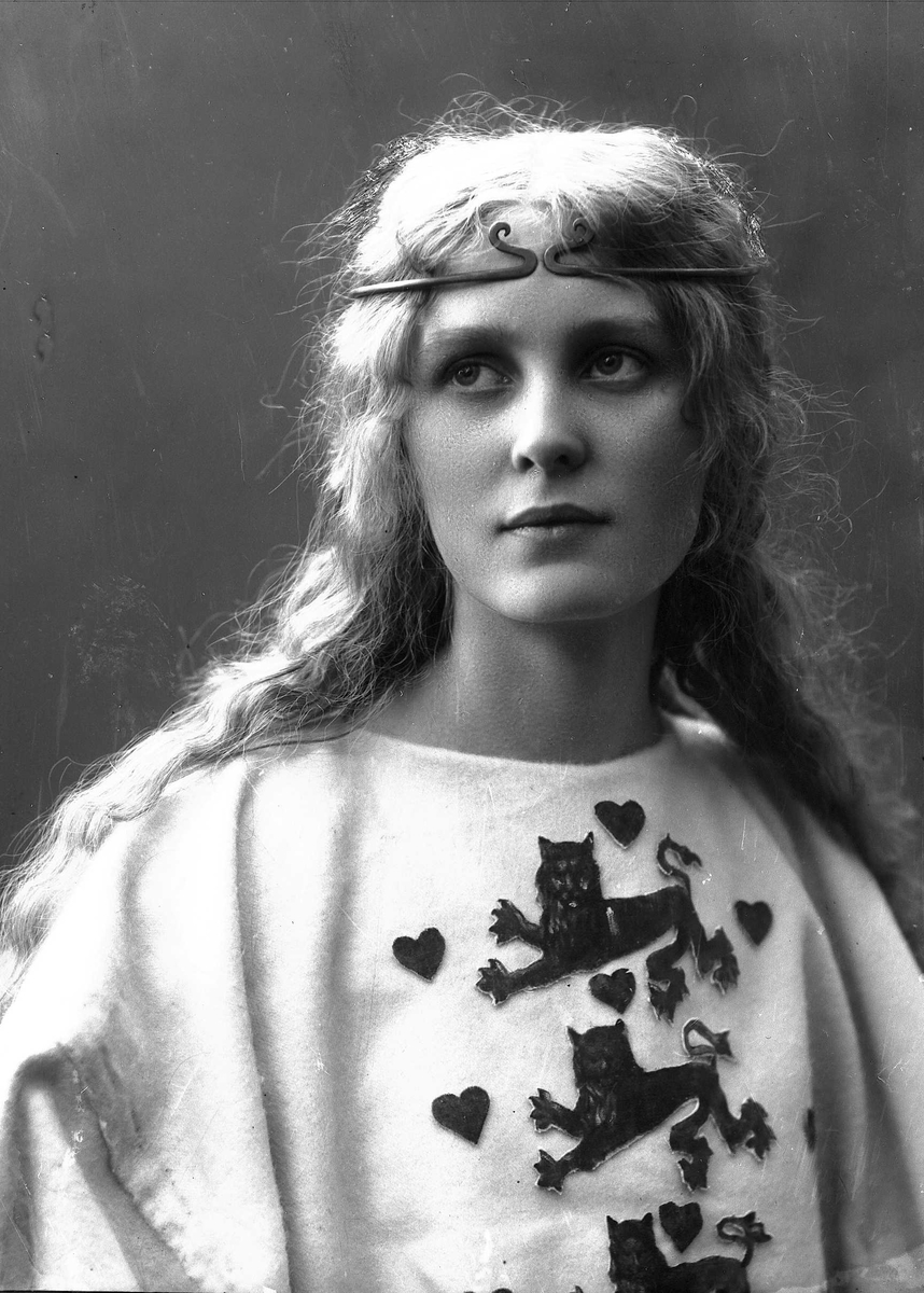 Solveig Lund, Brystportrett av kvinne i drakt med riksvåpen og hårsmykke.