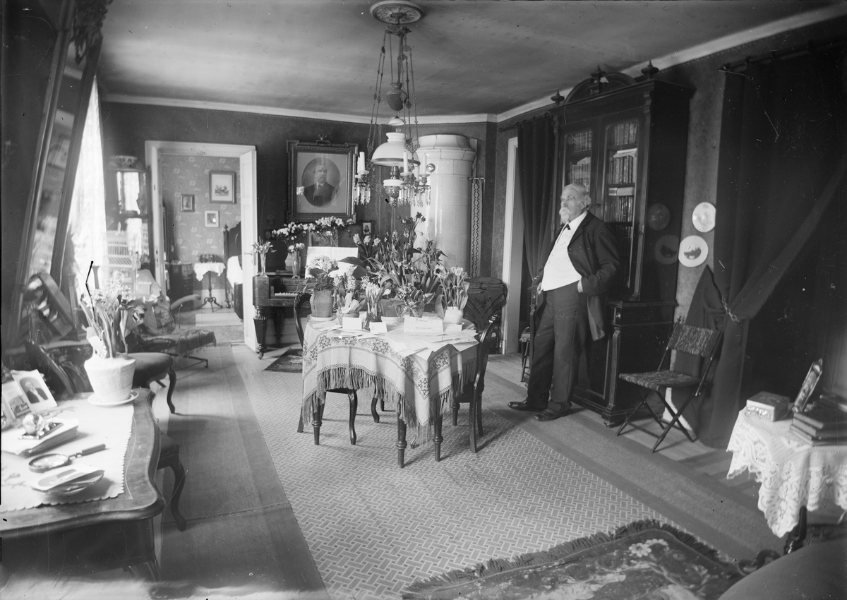 Henri Osti's Fotografiateliér, Fotografen Henri Osti i salongen i sitt hem, Bredgränd 11, Uppsala